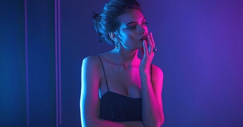 love doesn't exist - young woman with thinking pose under neon light