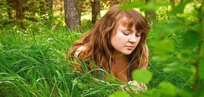 loving someone you can't be with - young woman looking forlorn amongst grass