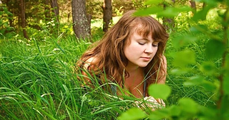 loving someone you can't be with - young woman looking forlorn amongst grass
