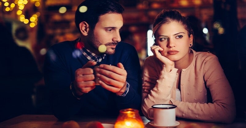 unhappy looking couple in bar