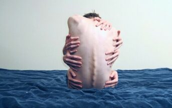 surreal image of depressed man holding himself with several arms to illustrate depression's dark thoughts