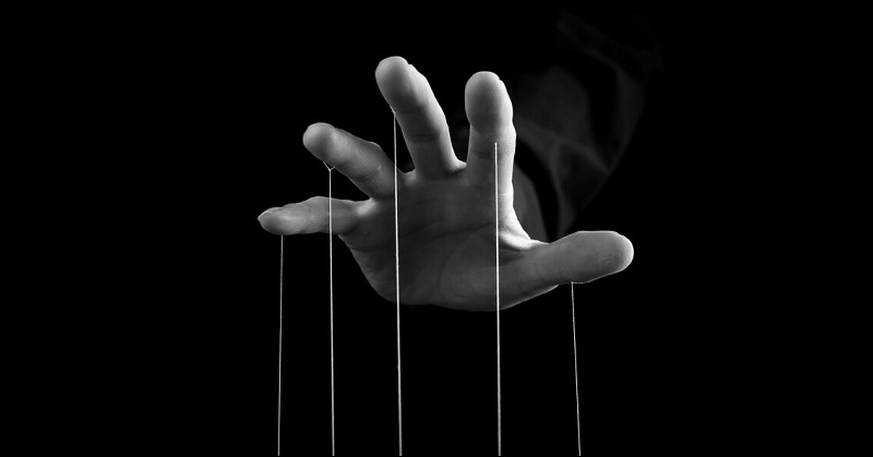 hand with strings coming from fingers indicating a controlling man