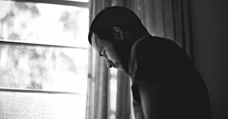 black and white photo of a depressed man thinking