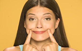 woman pushing mouth into a smile - illustrating being happy for others