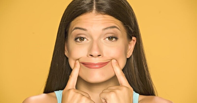 woman pushing mouth into a smile - illustrating being happy for others