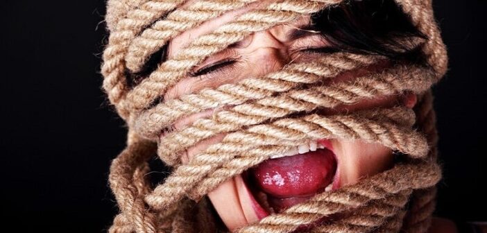 screaming woman with rope tied around her head and face illustrating having lost control of her thoughts