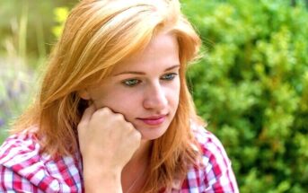 young woman looking pensive wondering why her ex is hiding his new girlfriend