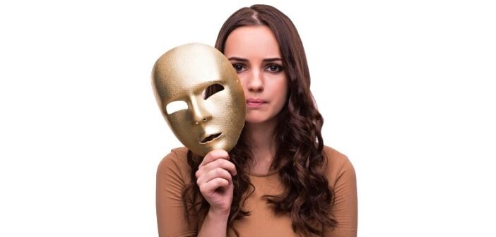 young pensive woman holding mask near her face because she can't be herself around others