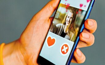 person holding phone with dating app open on the screen