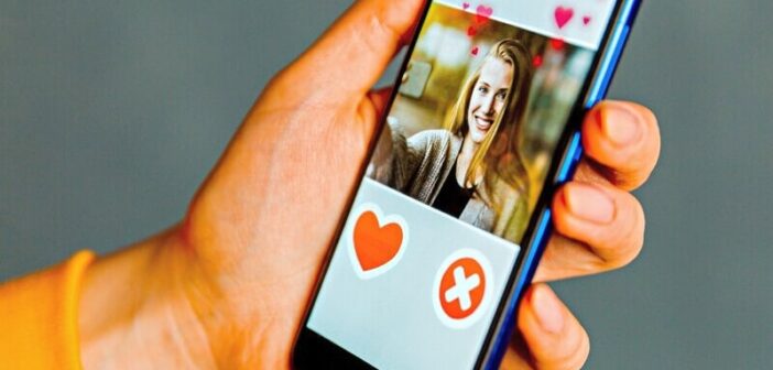 person holding phone with dating app open on the screen