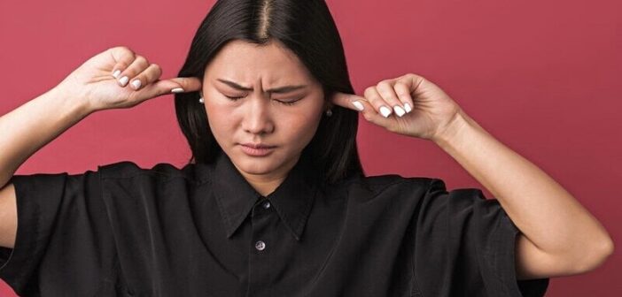 woman putting her fingers in her ears to silence the inner critic
