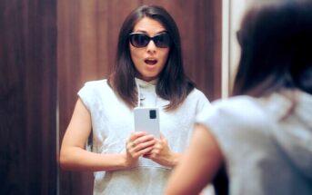 vain young woman taking selfie in designer clothes and sunglasses