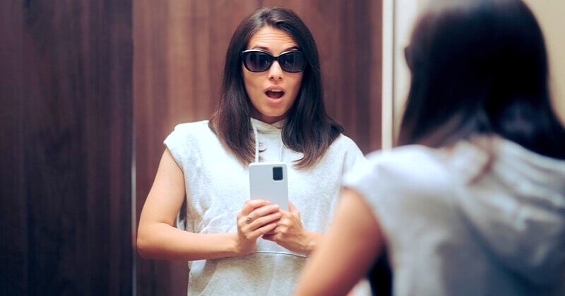 vain young woman taking selfie in designer clothes and sunglasses