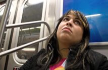 bored woman sitting on a subway train wondering "is this all there is to life?"