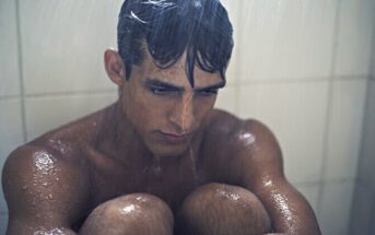 depressed man sitting in the shower