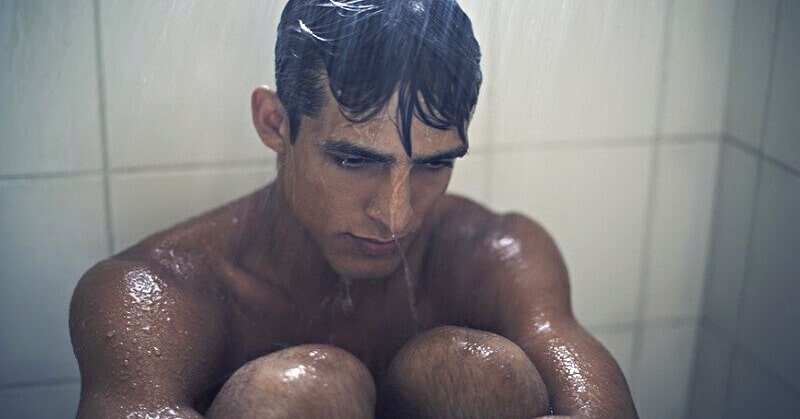 depressed man sitting in the shower