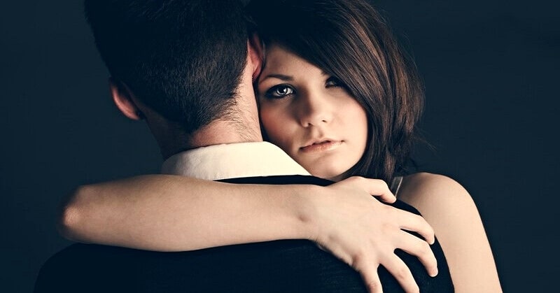 young woman with arms wrapped around her boyfriend