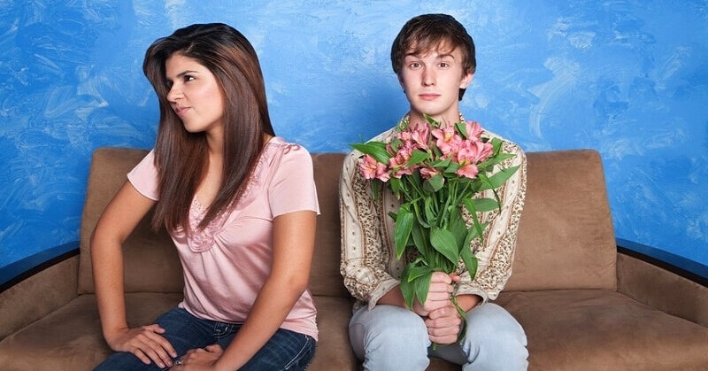 young man holding flowers while girl turns away - illustrating being a simp