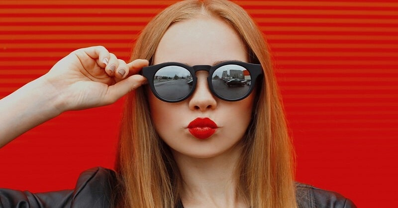 woman with sunglasses puckering her lips