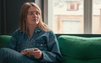 pensive young woman on couch because she hates socializing