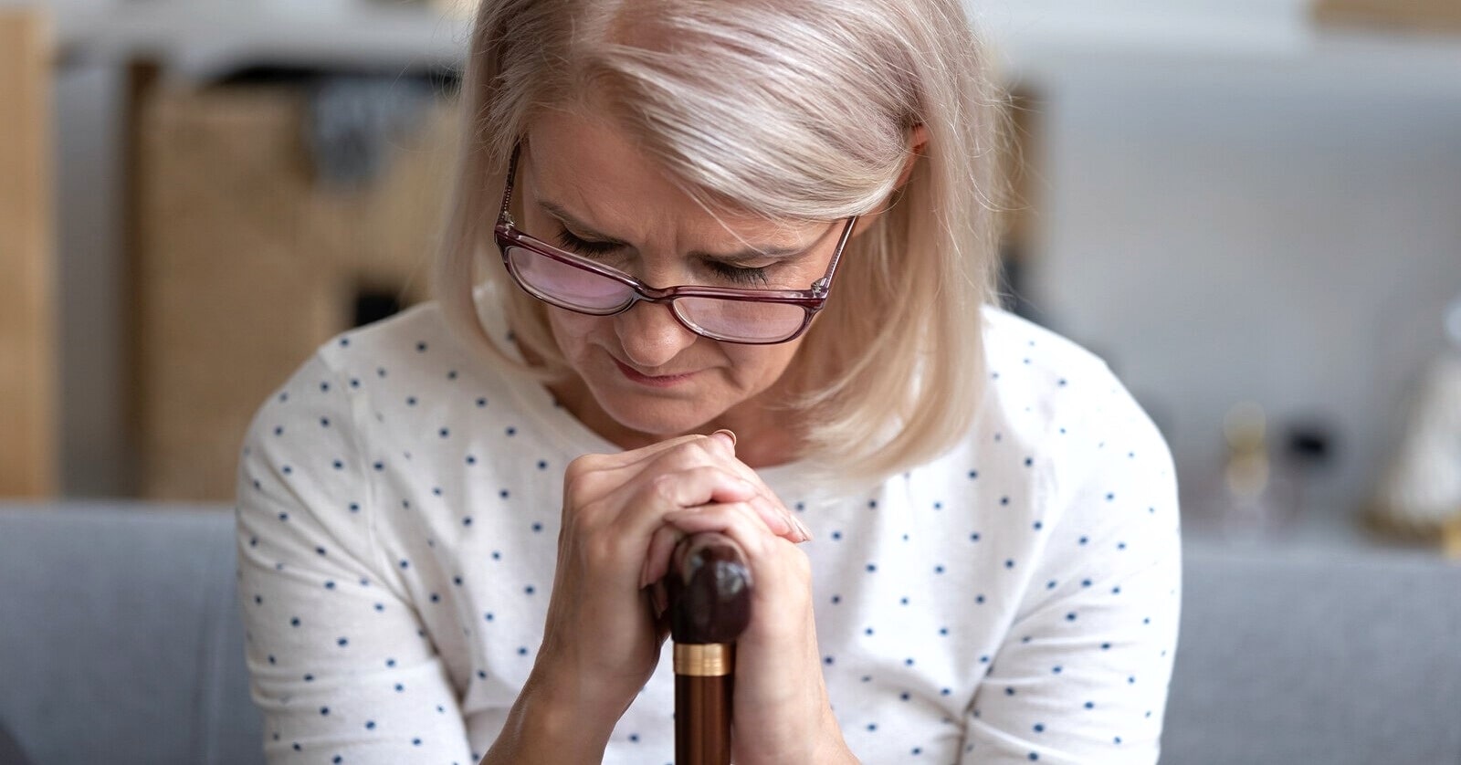 woman with walking stick who has recently experienced a loss of independence