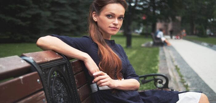 classy woman sitting on a park bench