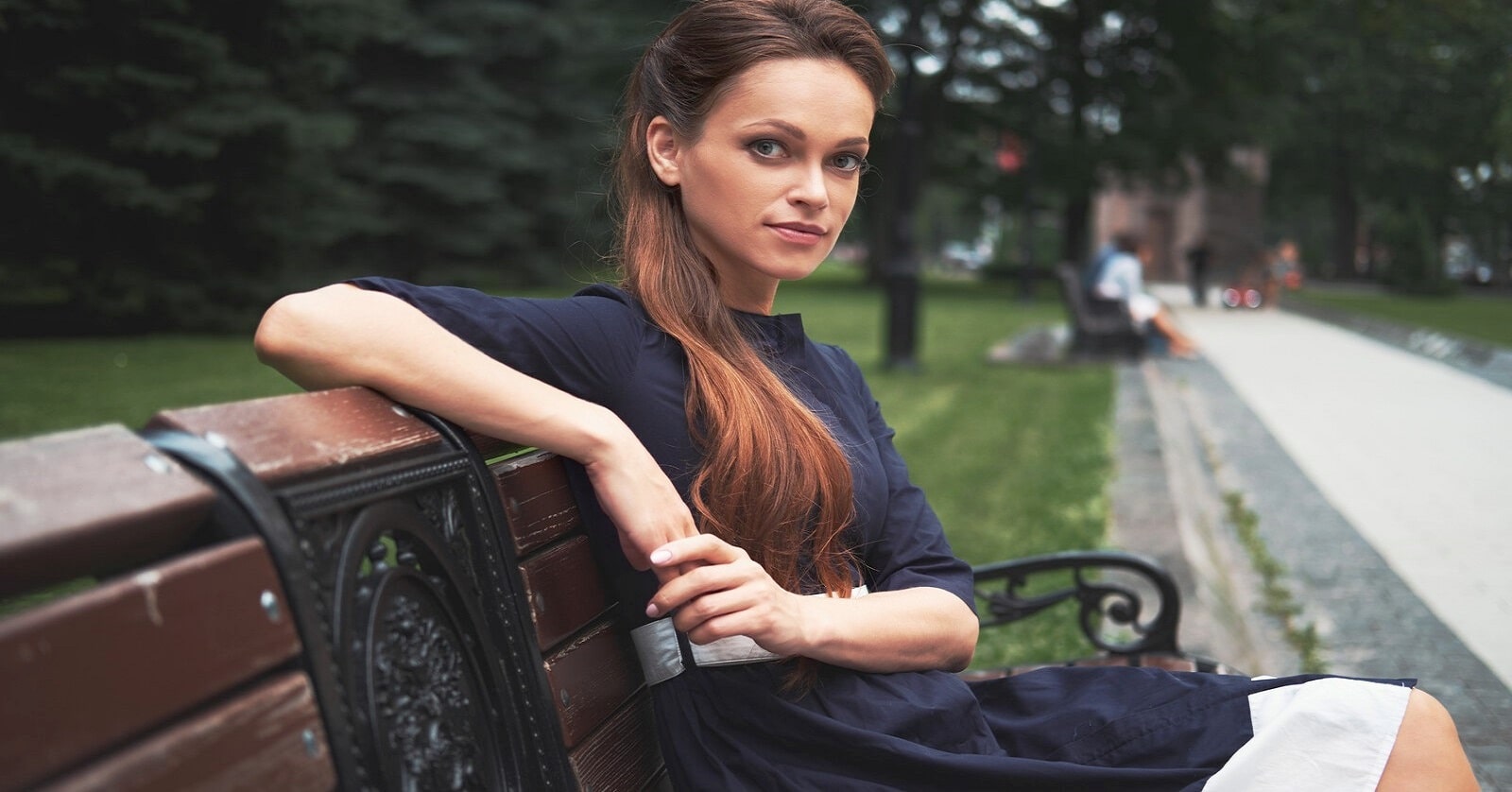 classy woman sitting on a park bench