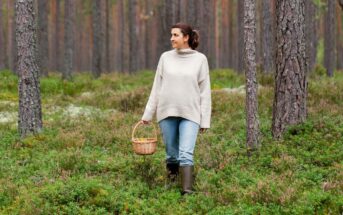 a down-to-earth woman walking through forest with a basket