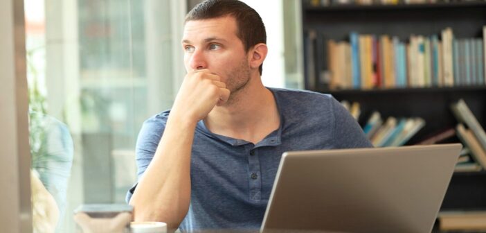 man sitting at laptop feeling the pressure