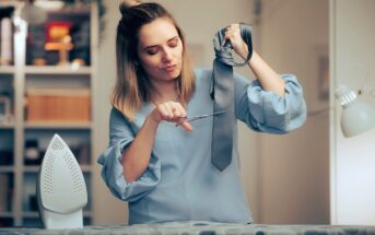 woman being crazy in a relationship by cutting her partner's tie because of jealousy or mistrust