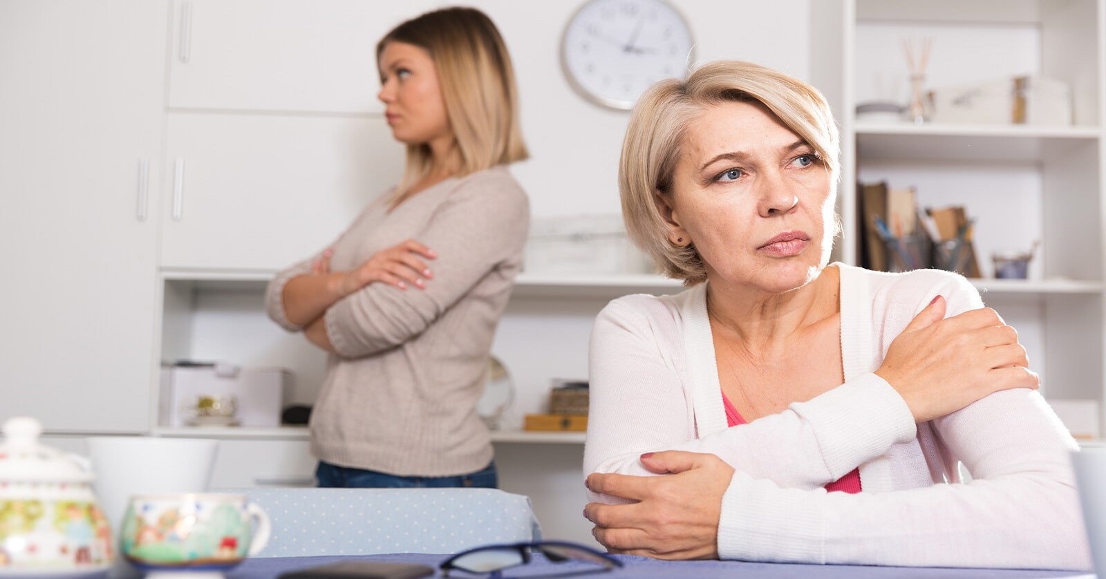 upset mother with grown daughter in the background