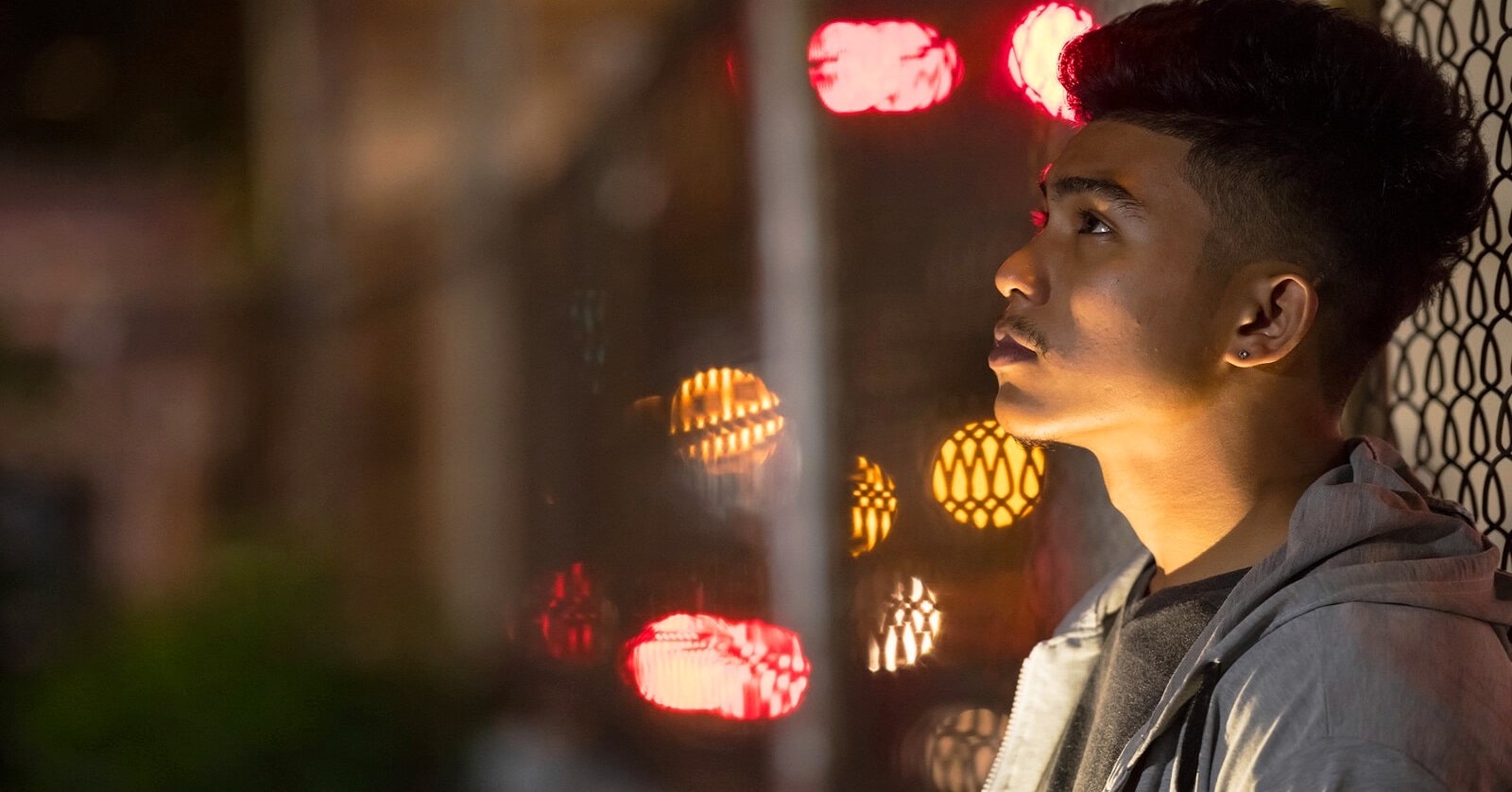 young man on street at night looking up because he doesn't understand life