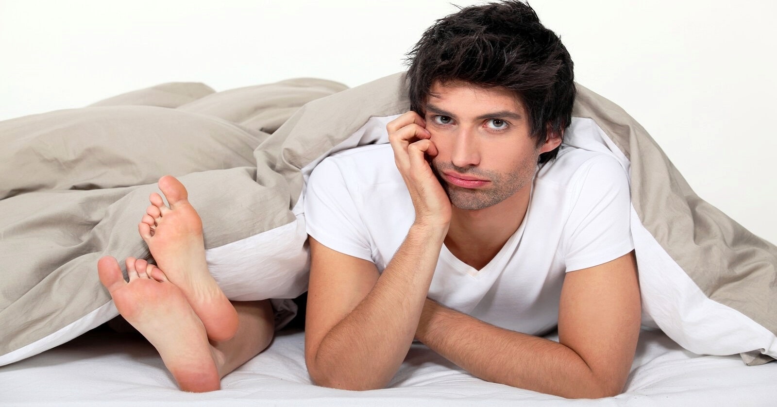 man looking bored in bed and showing signs of sexual frustration