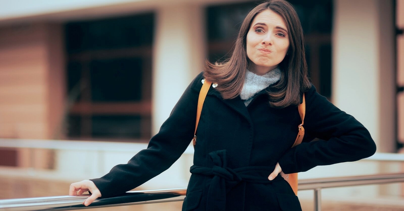 woman standing on street looking uptight with an exasperated look on her face