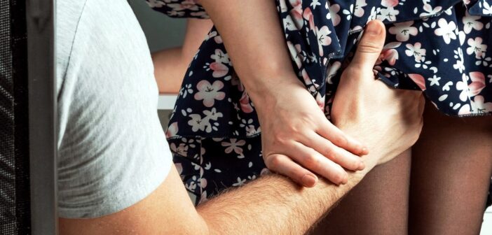 husband groping his wife by trying to put his hand up her skirt