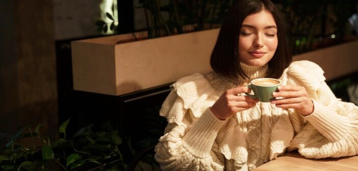 woman with eyes closed holding coffee - illustrating being in tune with yourself
