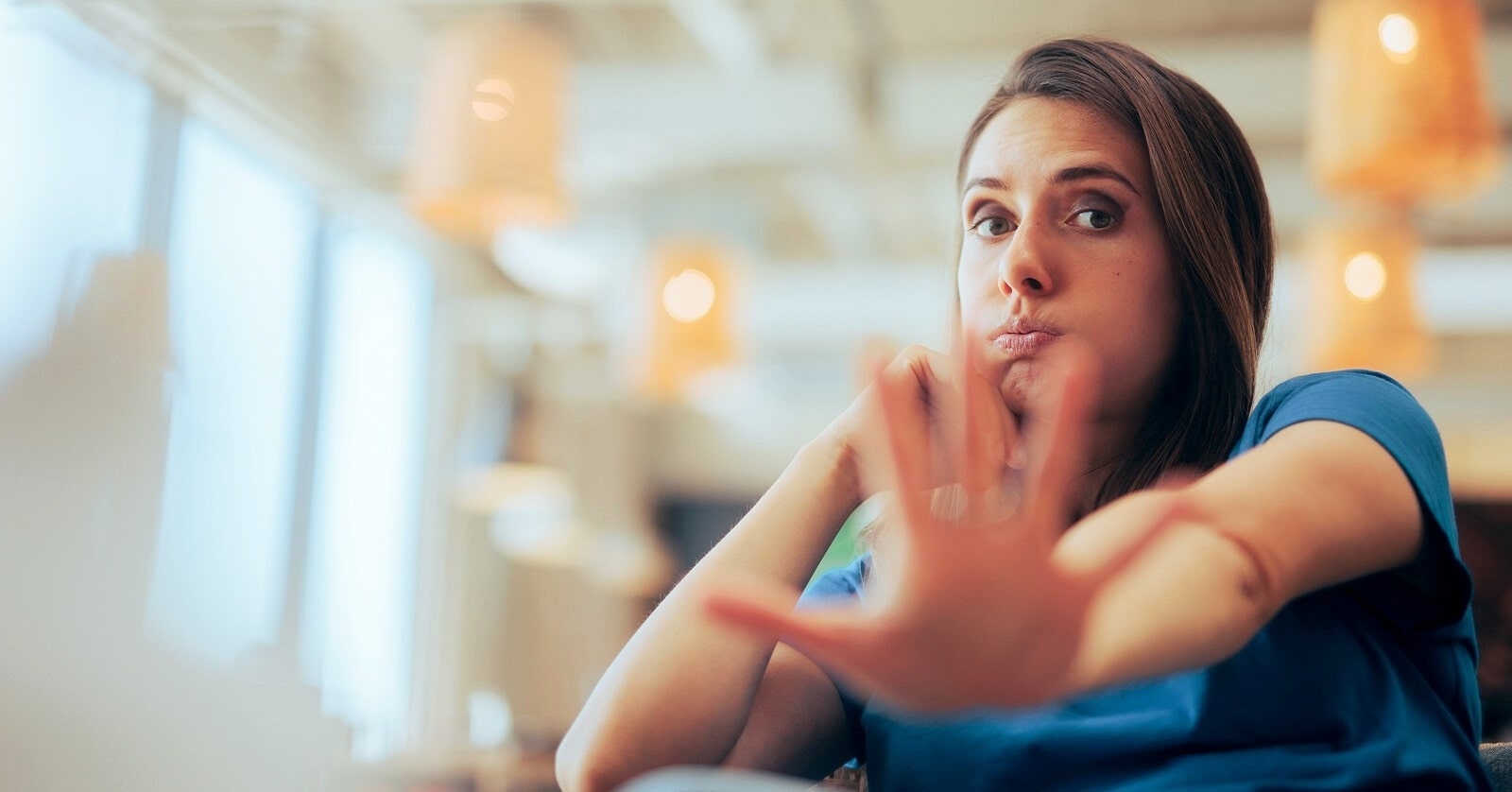 woman with outstretched hand with palm facing the camera indicating that she doesn't want to deal with you