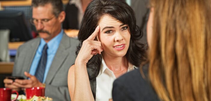 woman looking irritated as her friend gives her unsolicited advice in a cafe