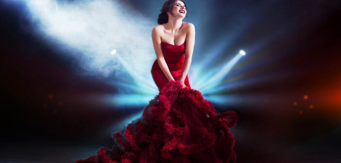 woman in striking red dress standing in several spotlights - illustrating an attention-seeker