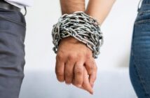 man and woman holding hands with a chain around their hands to illustrate a narcissistic relationship