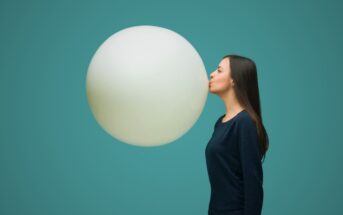 woman blowing up huge balloon