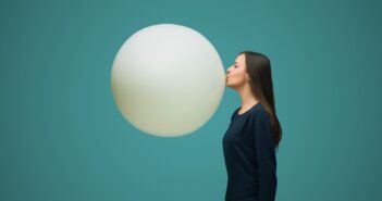 woman blowing up huge balloon