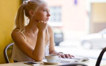 pensive woman in coffee shop looking out of the window