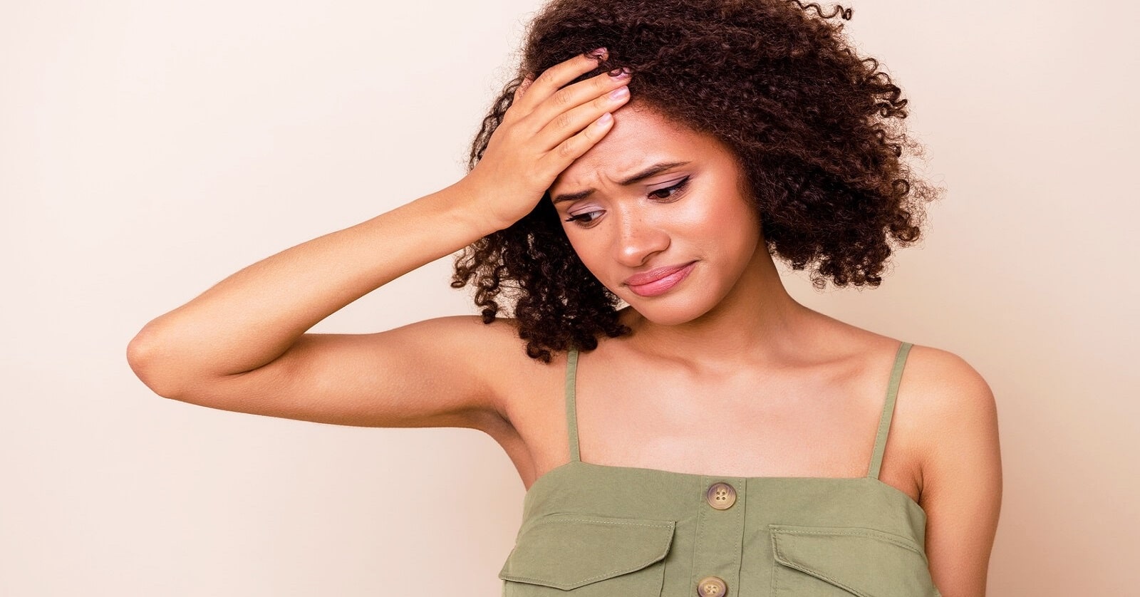 young woman with a distressed look on her face and her hand on her forehead illustrating feeling incompetent