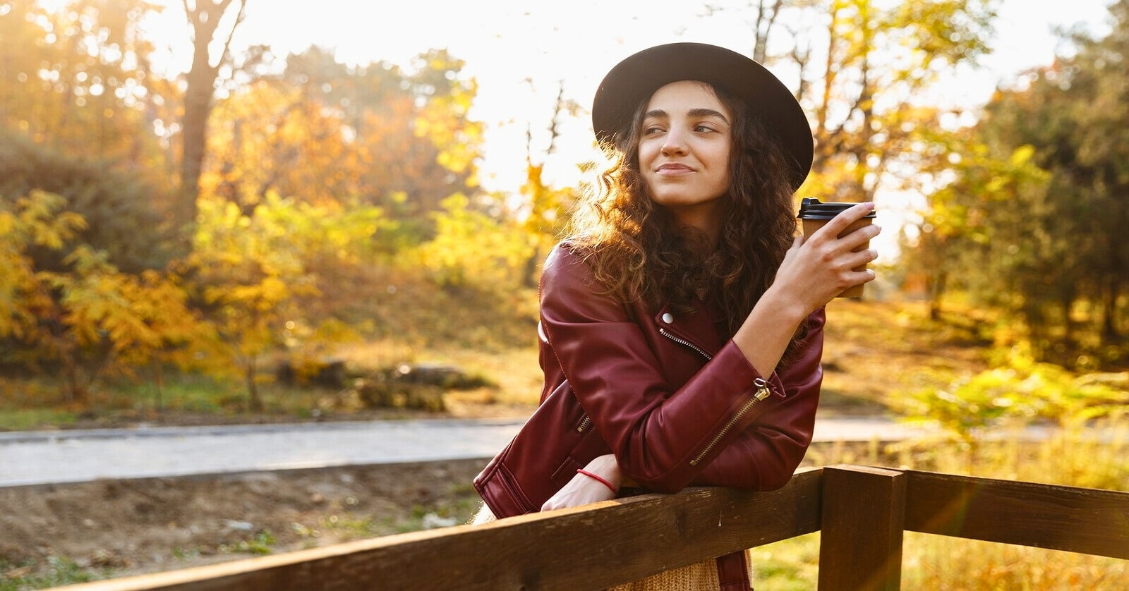 young woman in natural setting drinking store bought coffee