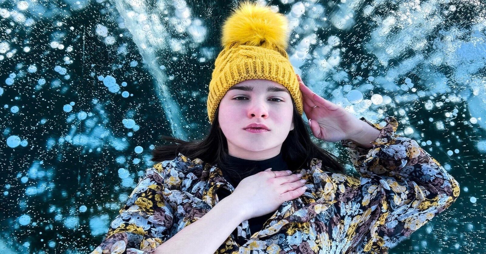 young woman with yellow hat lying down on ice
