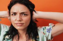 woman with hands over her ears because she's fed up of listening to someone complain