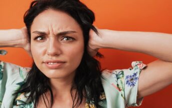 woman with hands over her ears because she's fed up of listening to someone complain