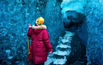 woman walking through a blue ice cave - illustrating the concept of perseverance