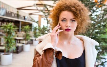 trendy red head woman holding phone